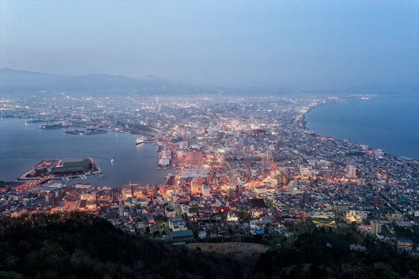日が沈んで明かりが灯ってきた時間帯の函館山から見る夜景