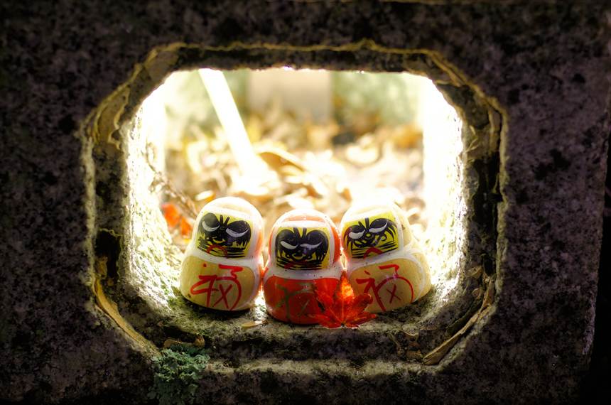 光る灯篭の中の３体のダルマ